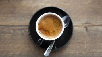 فنجان قهوة بجانب حبوب البن