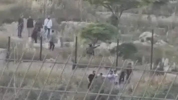 مشهد لإخراج الجثمان الفلسطيني قرب جنود ومستوطنين