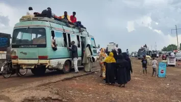 لاجئون سودانيون يحملون أمتعتهم أثناء النزوح من منطقة نيلية