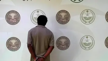دورية شرطة سعودية تقف أمام سيارة موقوفة