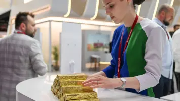 سبائك ذهبية بجانب دولارات أمريكية رمزاً للسلع المسعرة بالدولار