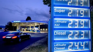 Gasoline pump at a station displaying high fuel prices