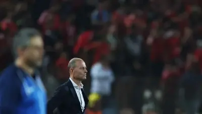مدرب كرة قدم بجانب شعار النادي الأهلي