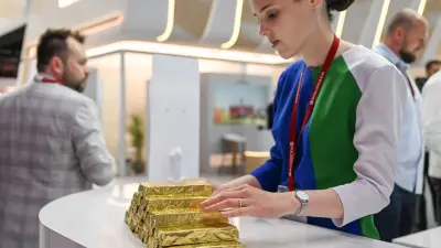 سبائك ذهبية بجانب دولارات أمريكية رمزاً للسلع المسعرة بالدولار