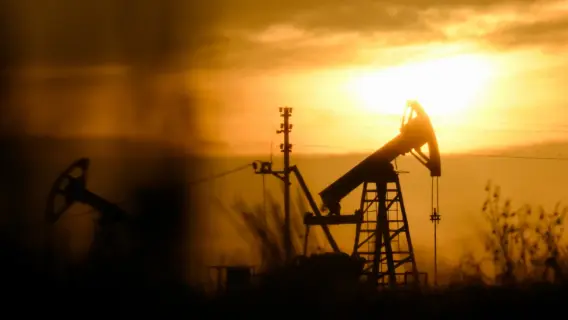 Oil barrels with a backdrop of a financial graph indicating rising prices.