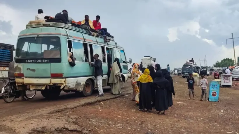 لاجئون سودانيون يحملون أمتعتهم أثناء النزوح من منطقة نيلية